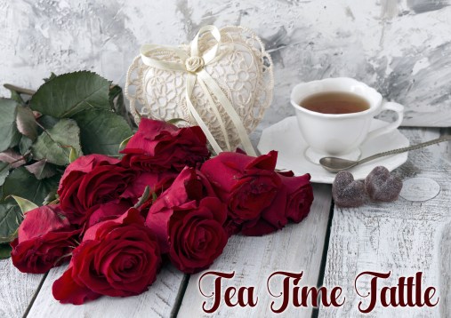 on a white wooden table red roses, cup of tea, heart made of lac